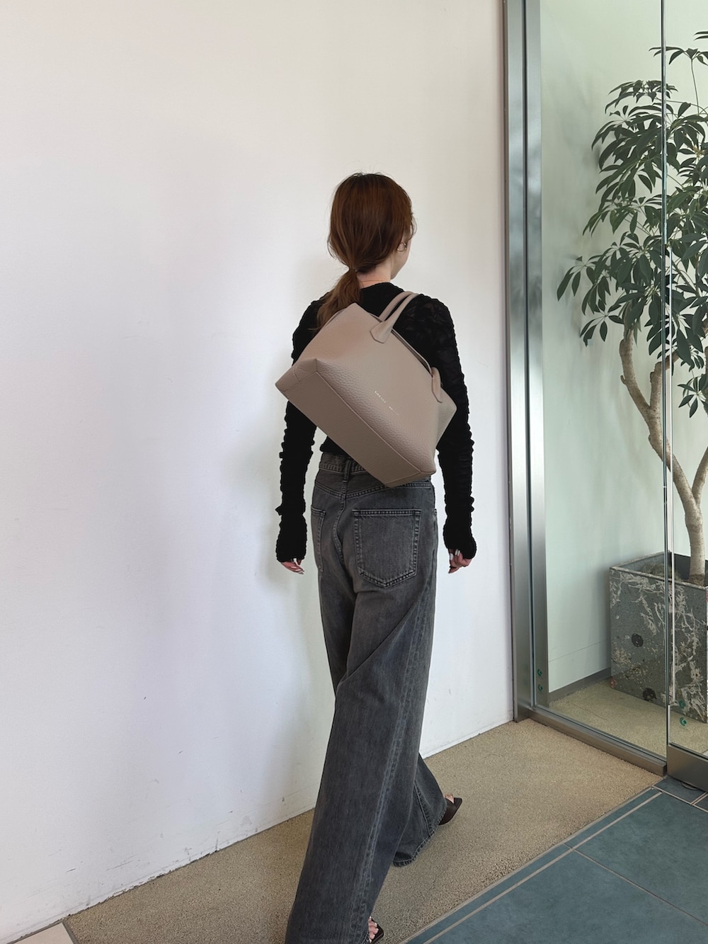 グレー系のデニムパンツを着用したレディースの春コーディネートの3枚目の写真