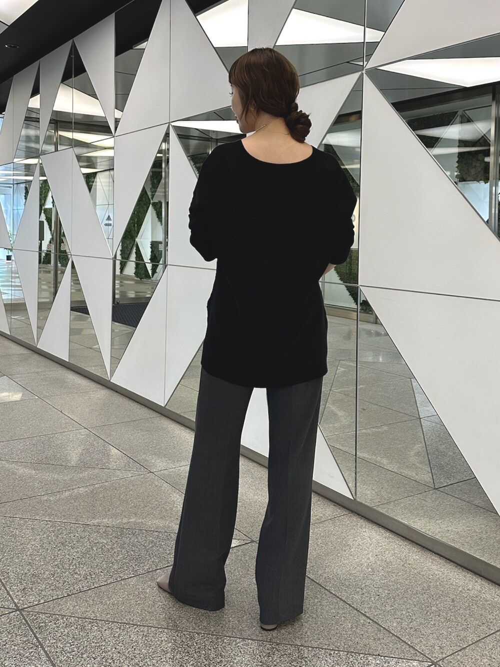 グレー系のブーツ、ブラック系のニット/セーター、ゴールド系のチョーカーを着用したレディースの夏コーディネートの3枚目の写真