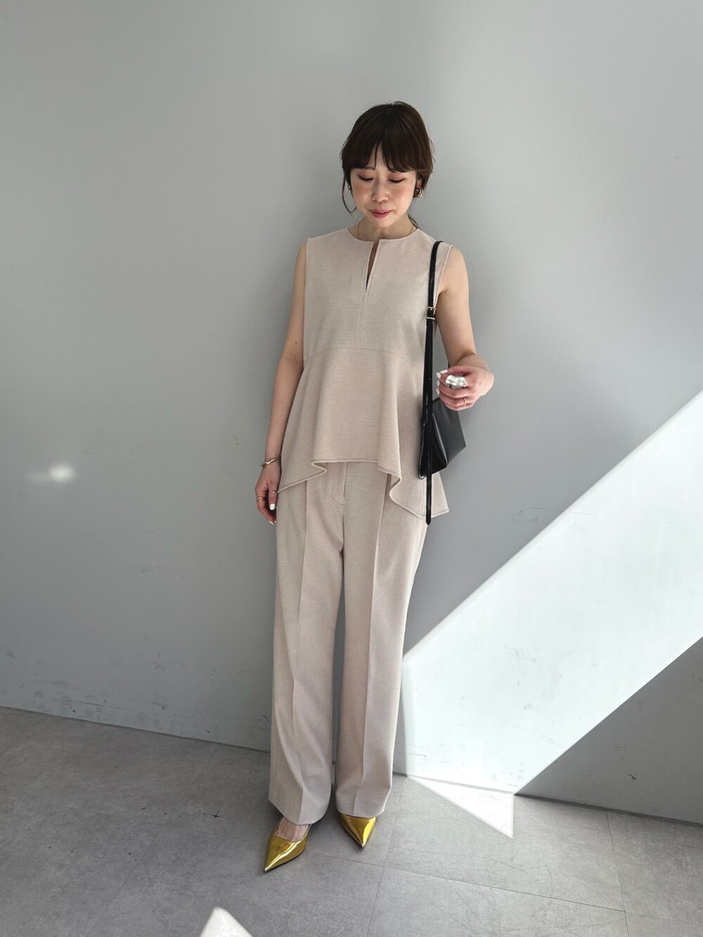 ピンク系のスラックス、ピンク系のシャツ/ブラウス、ブラウン系のショルダーバッグを着用したレディースの春コーディネートの3枚目の写真