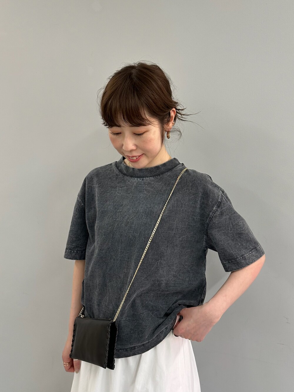 ホワイト系のスカート、グレー系のTシャツ/カットソー、ブラック系のショルダーバッグを着用したレディースの春コーディネートの4枚目の写真