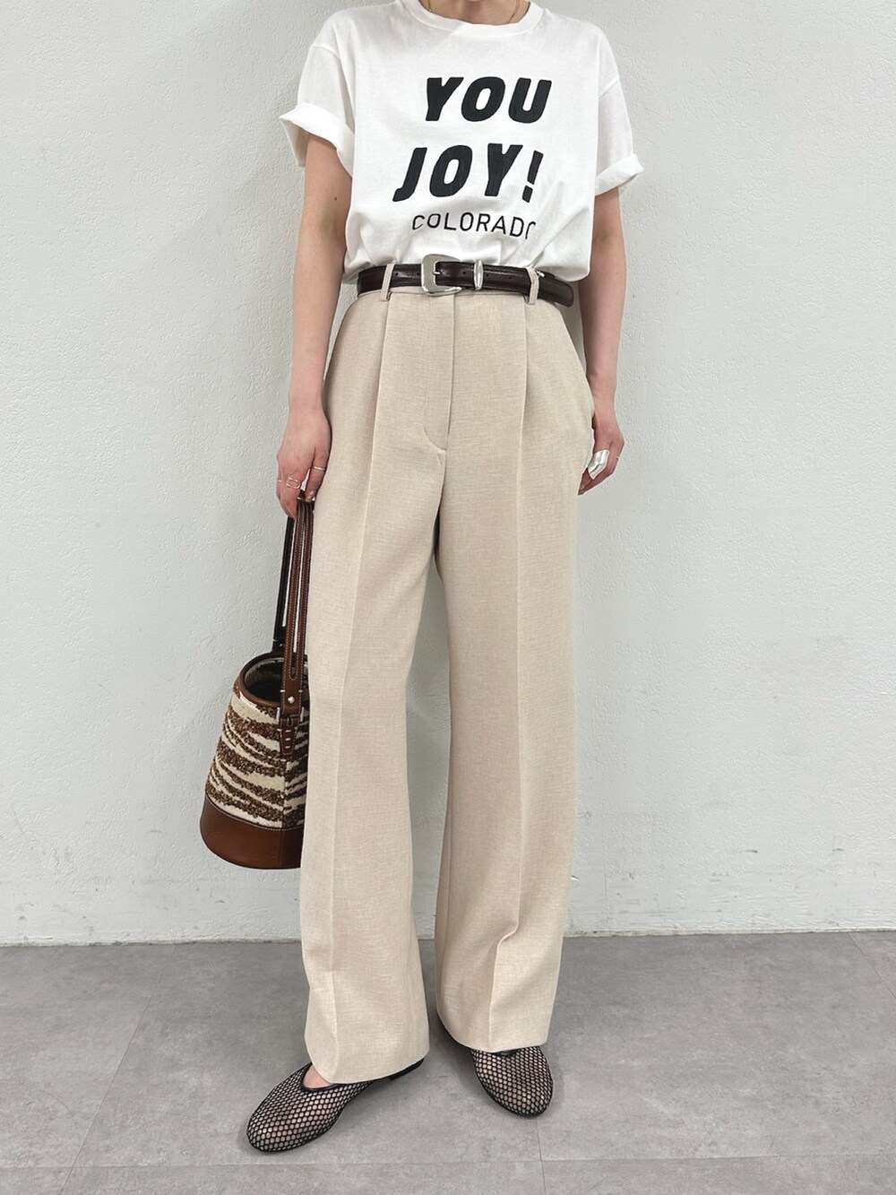 ホワイト系のTシャツ/カットソー、ピンク系のスラックス、ブラック系のパンプスを着用したレディースの春コーディネートの6枚目の写真