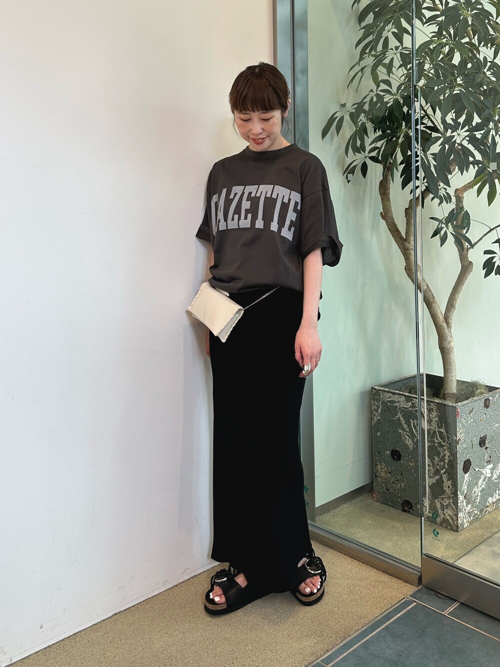 ブラック系のショルダーバッグ、グレー系のTシャツ/カットソーを着用したレディースの春コーディネートの2枚目の写真