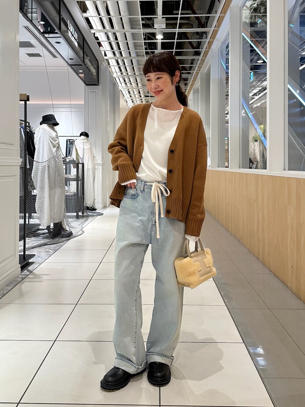 ブラウン系のカーディガン/ボレロ、ブルー系のデニムパンツを着用したレディースの秋コーディネートの4枚目の写真