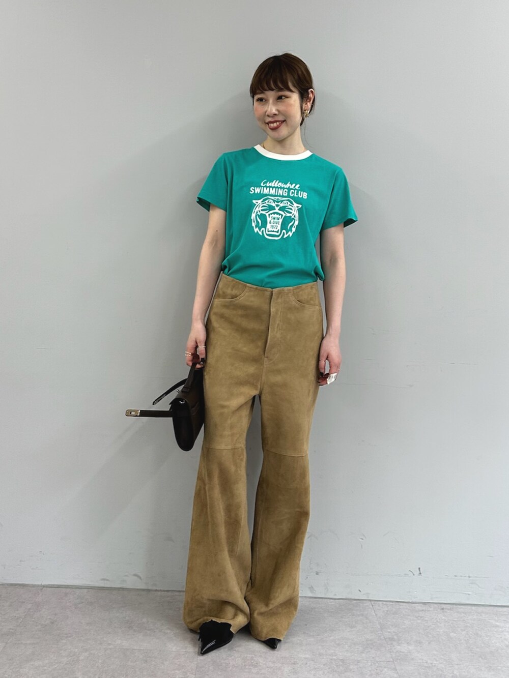 グリーン系のTシャツ/カットソー、イエロー系のその他パンツ、ブラウン系のハンドバッグを着用したレディースの春コーディネートの6枚目の写真