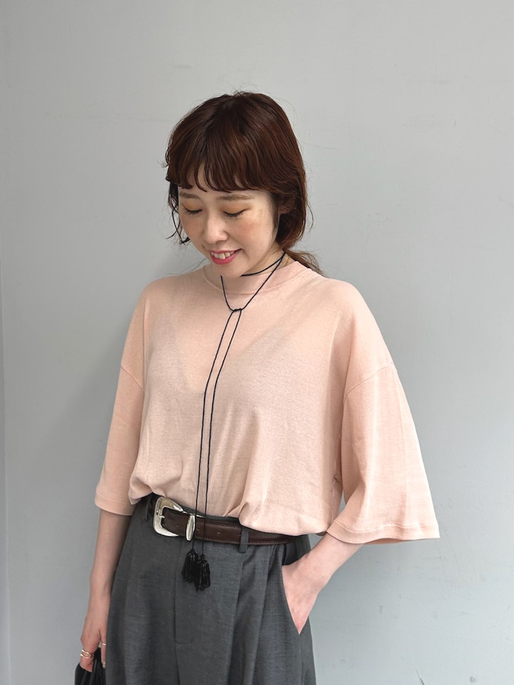 グレー系のスラックス、ブラック系のボストンバッグ、イエロー系のパンプスを着用したレディースの夏コーディネートの6枚目の写真