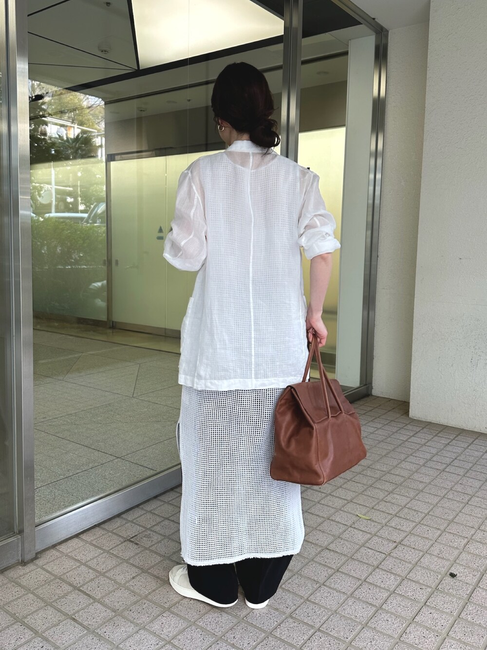 ホワイト系のテーラードジャケット、イエロー系のボストンバッグ、ホワイト系のスニーカーを着用したレディースの春コーディネートの3枚目の写真