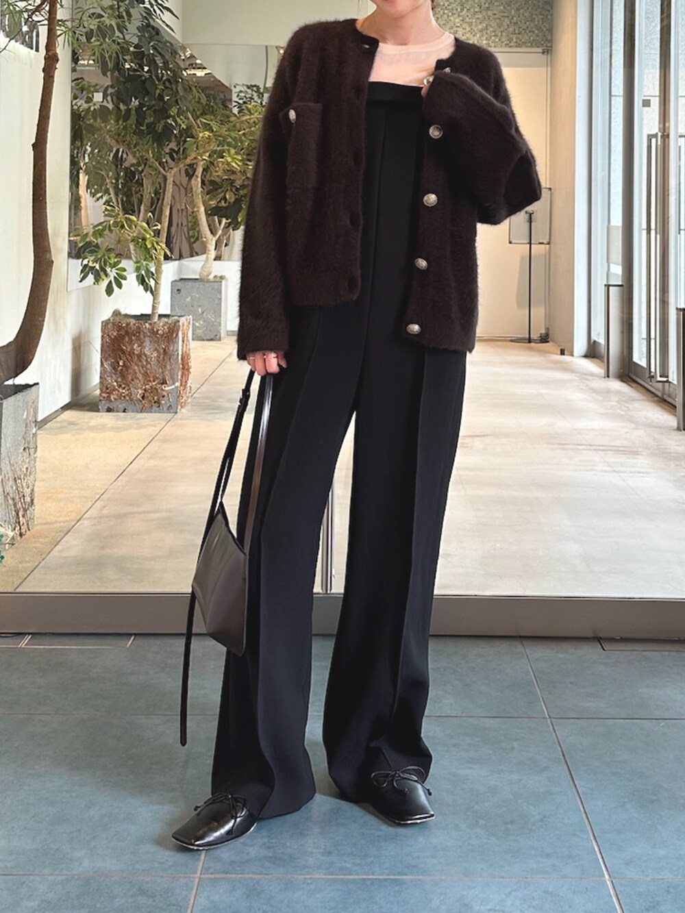 ブラック系のサロペット/オーバーオール、ホワイト系のシャツ/ブラウス、ブラウン系のショルダーバッグを着用したレディースの秋コーディネートの5枚目の写真