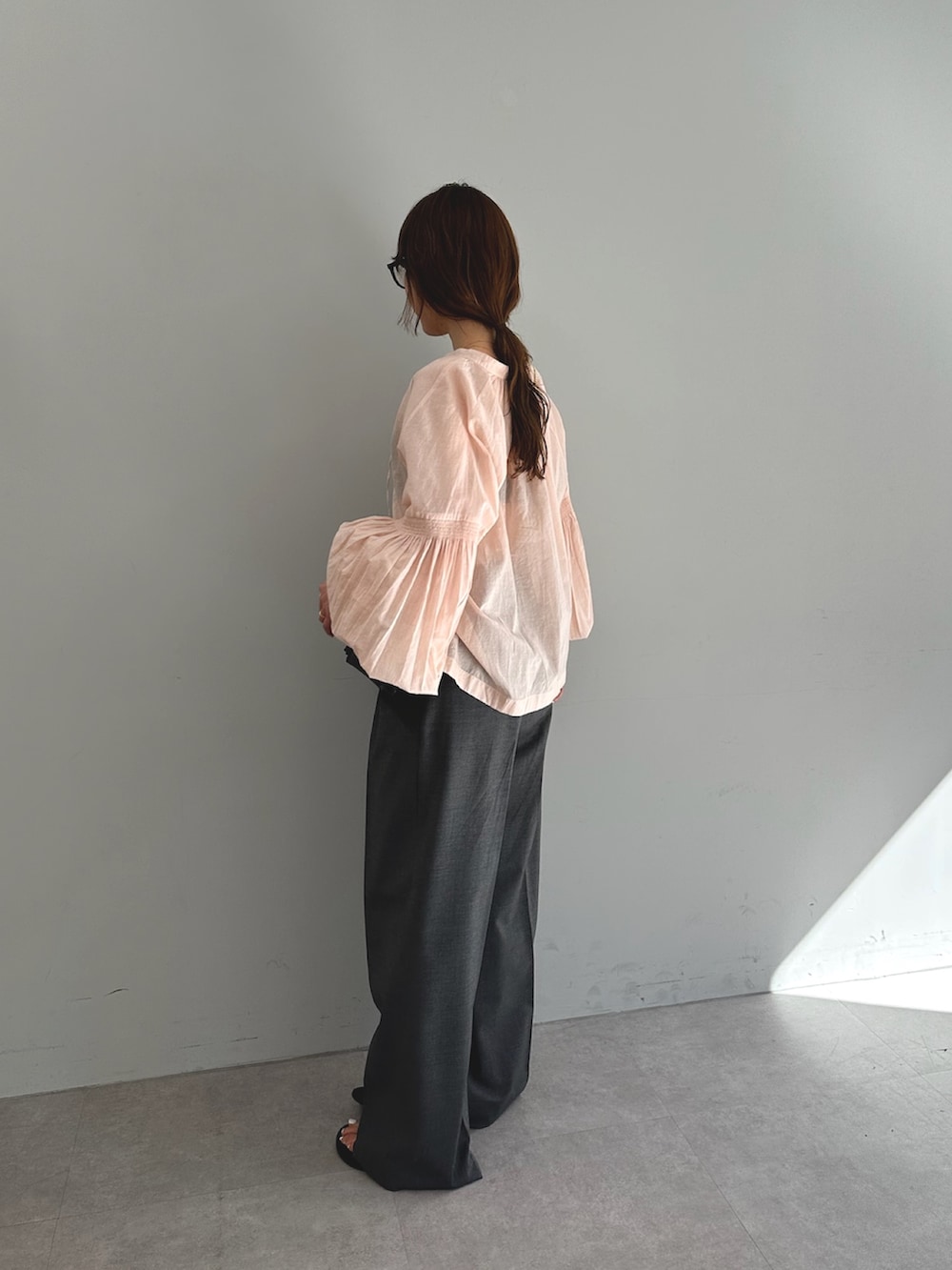 ピンク系のシャツ/ブラウス、グレー系のスラックス、ブラック系のショルダーバッグを着用したレディースの春コーディネートの4枚目の写真