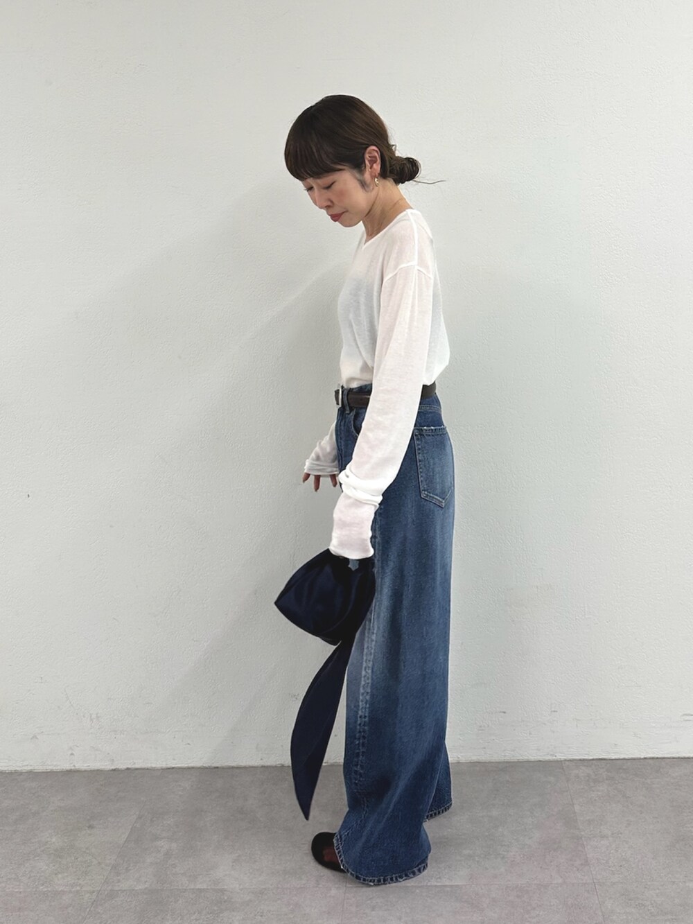 ホワイト系のTシャツ/カットソー、ブルー系のデニムパンツ、ブラウン系のサンダルを着用したレディースの春コーディネートの2枚目の写真