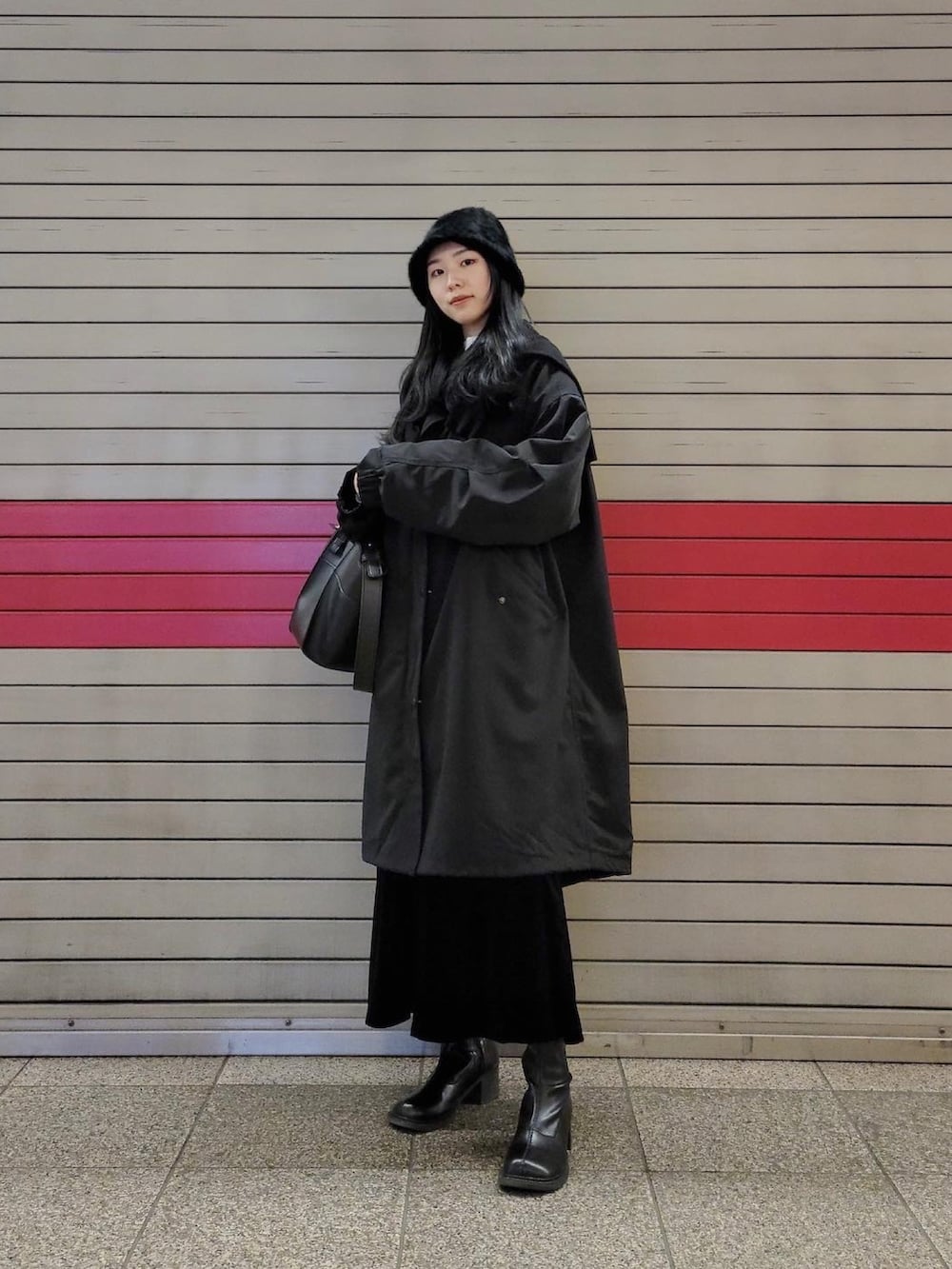 ブラック系のモッズコート、ブラック系のワンピース、ブラック系のシューズを着用したレディースの冬コーディネートの3枚目の写真