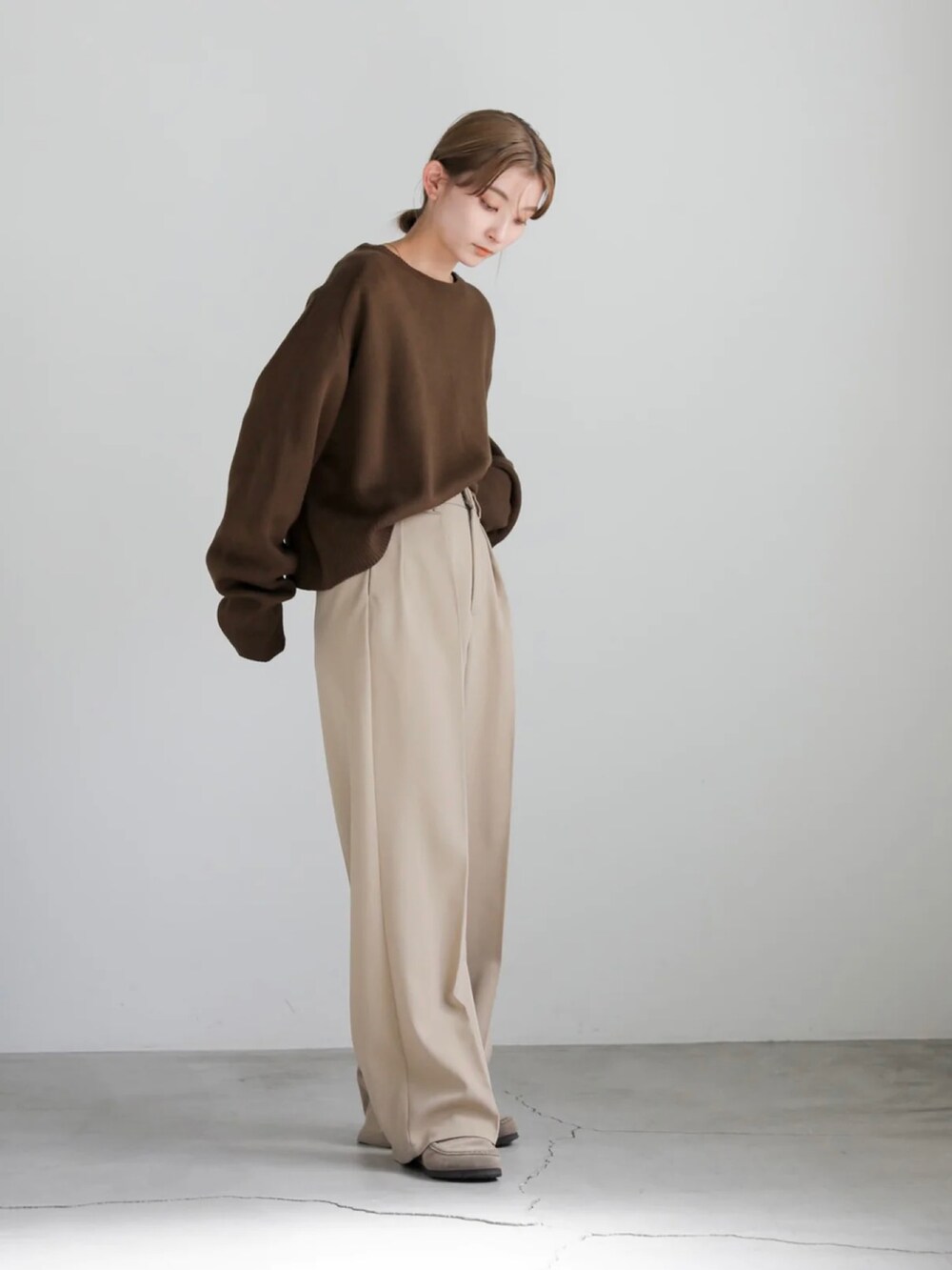 ブラック系のニット/セーター、ベージュ系のスラックスを着用したレディースの秋コーディネートの4枚目の写真