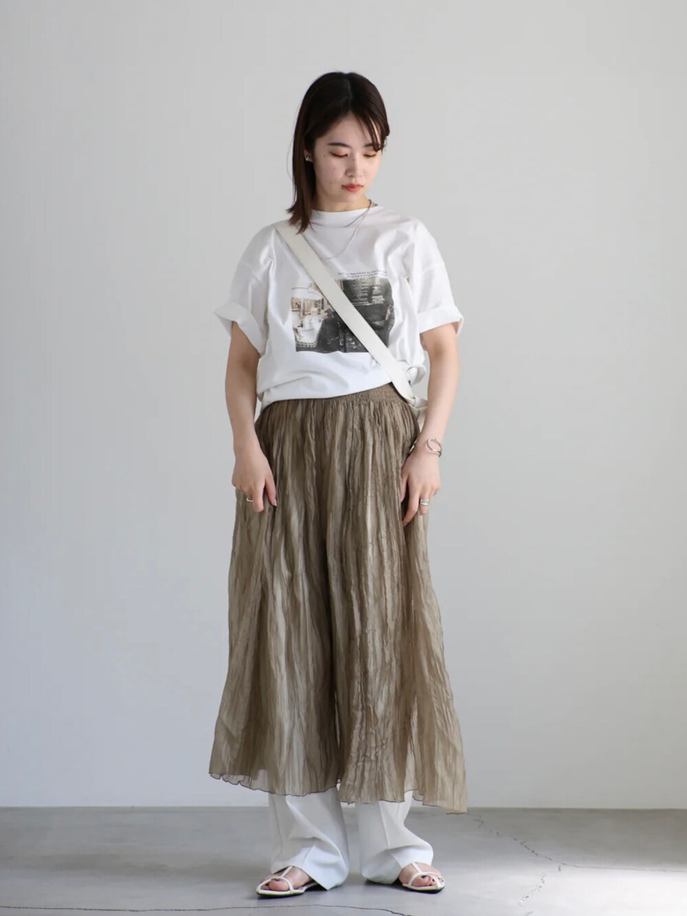 ホワイト系のTシャツ/カットソー、ホワイト系のスラックス、ブラウン系のワンピースを着用したレディースの夏コーディネートの4枚目の写真