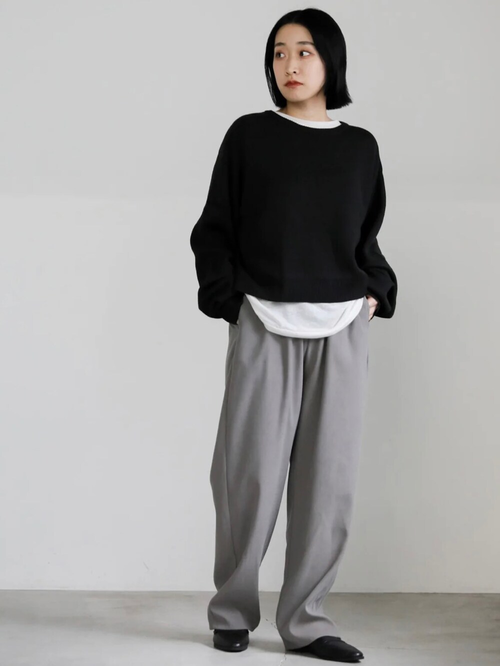 ブラック系のニット/セーター、グレー系のその他パンツを着用したレディースの冬コーディネートの4枚目の写真