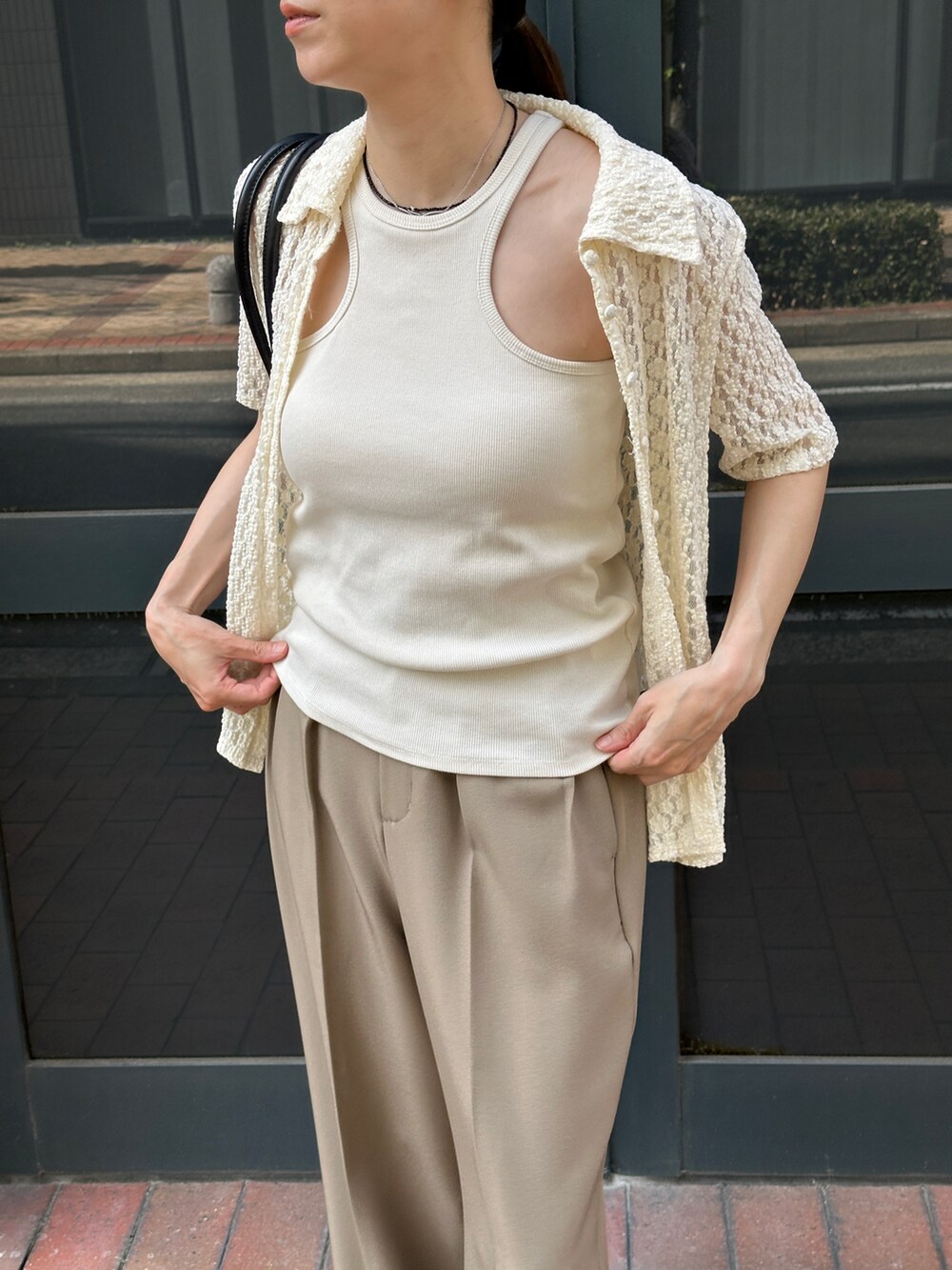 ホワイト系のタンクトップ、ホワイト系のシャツ/ブラウス、ベージュ系のスラックスを着用したレディースの春コーディネートの3枚目の写真