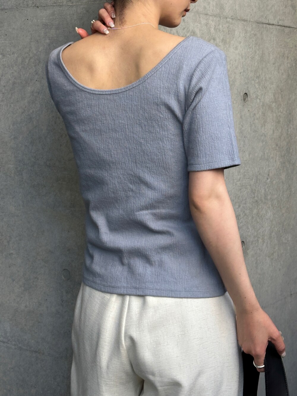 ブルー系のTシャツ/カットソー、ホワイト系のスラックス、ブラック系のトートバッグを着用したレディースの春コーディネートの4枚目の写真