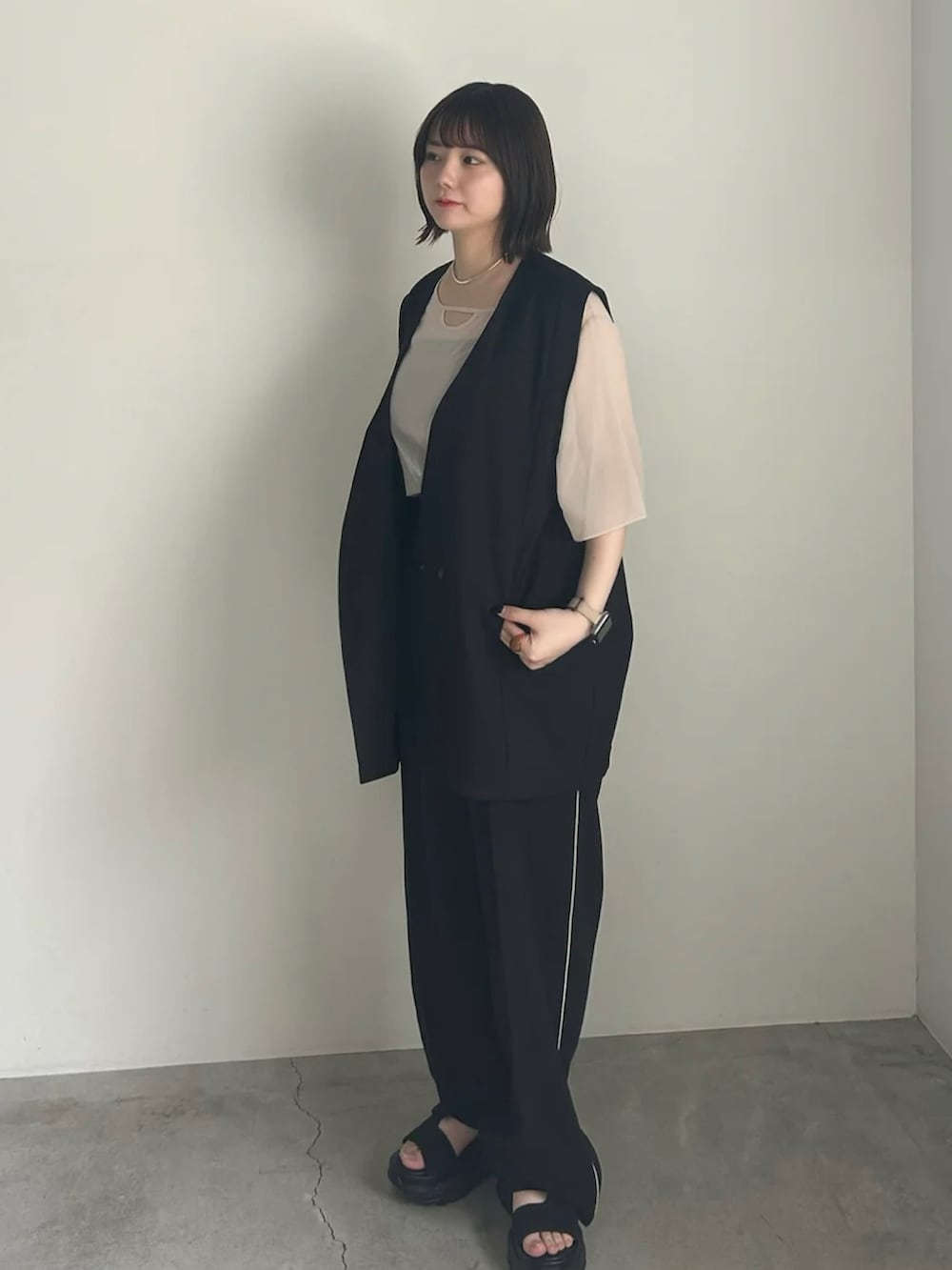 ホワイト系のシャツ/ブラウス、ブラック系のベスト、ブラック系のスラックスを着用したレディースの春コーディネートの2枚目の写真