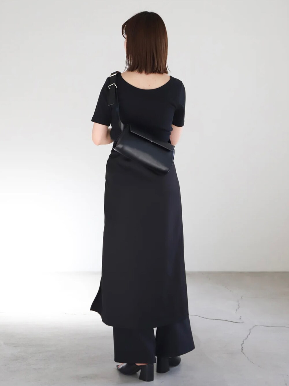 ブラック系のTシャツ/カットソー、ブラック系のスカート、ブラック系のスラックスを着用したレディースの春コーディネートの3枚目の写真