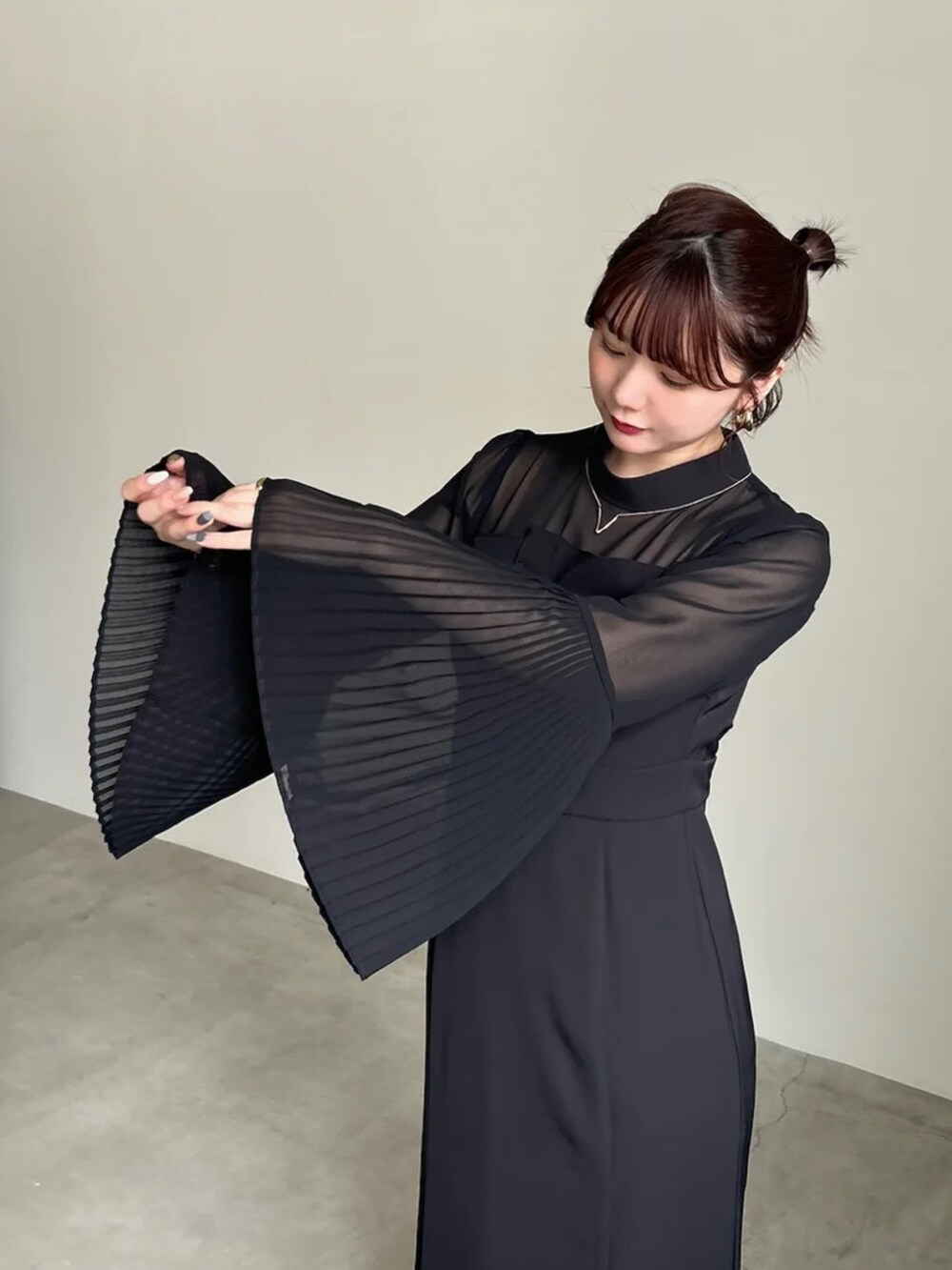 グレー系のワンピース、ブラック系のショルダーバッグ、ブラック系のパンプスを着用したレディースの春コーディネートの4枚目の写真