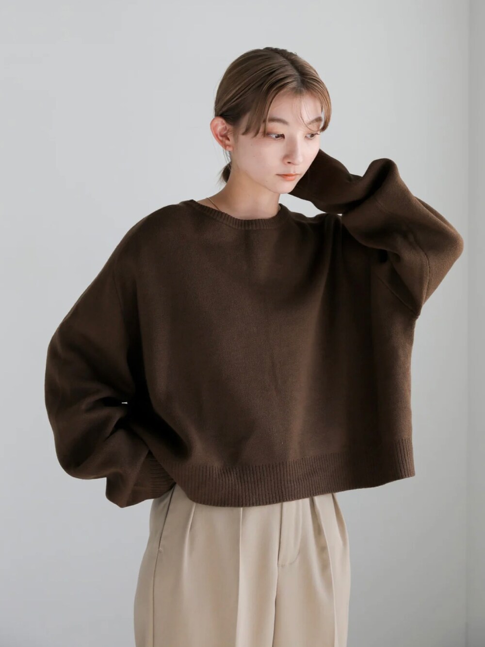 ブラック系のニット/セーター、ベージュ系のスラックスを着用したレディースの秋コーディネートの5枚目の写真