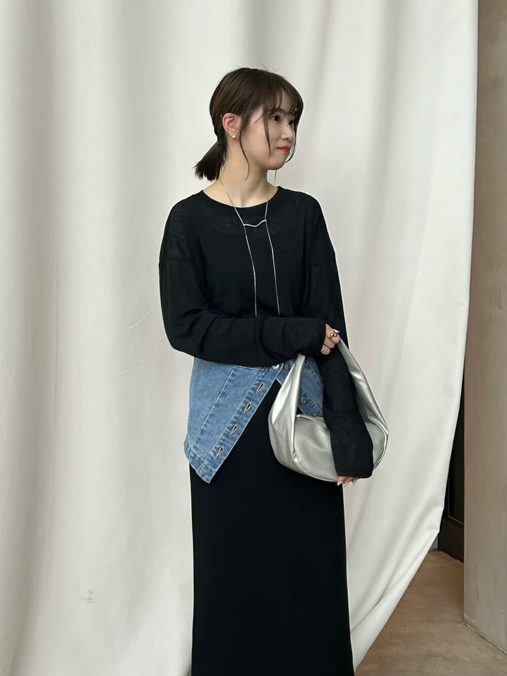 ブラック系のTシャツ/カットソー、ブラック系のスカート、ブルー系のチューブトップを着用したレディースの冬コーディネートの2枚目の写真