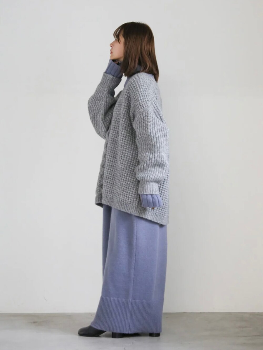 グレー系のカーディガン/ボレロ、ブルー系のワンピースを着用したレディースの冬コーディネートの2枚目の写真