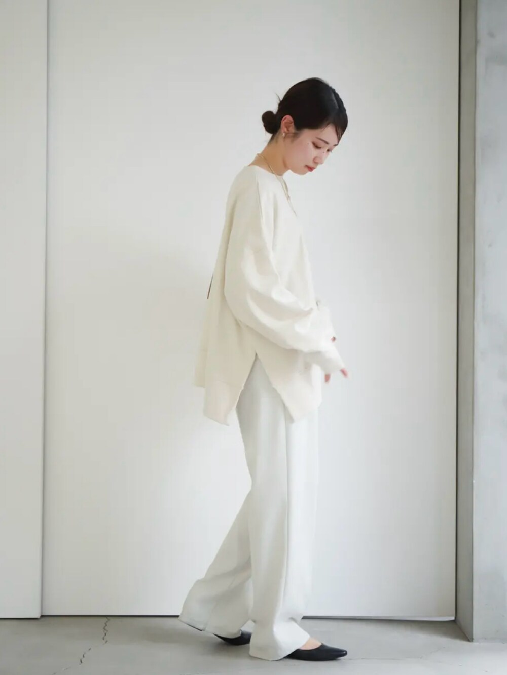 ホワイト系のスウェット、ホワイト系のスラックス、ベージュ系のショルダーバッグを着用したレディースの冬コーディネートの5枚目の写真