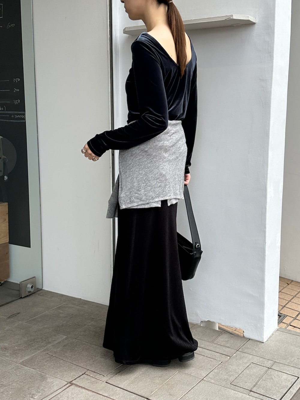 ブルー系のTシャツ/カットソー、グレー系のカーディガン/ボレロ、ブラック系のスカートを着用したレディースの冬コーディネートの2枚目の写真