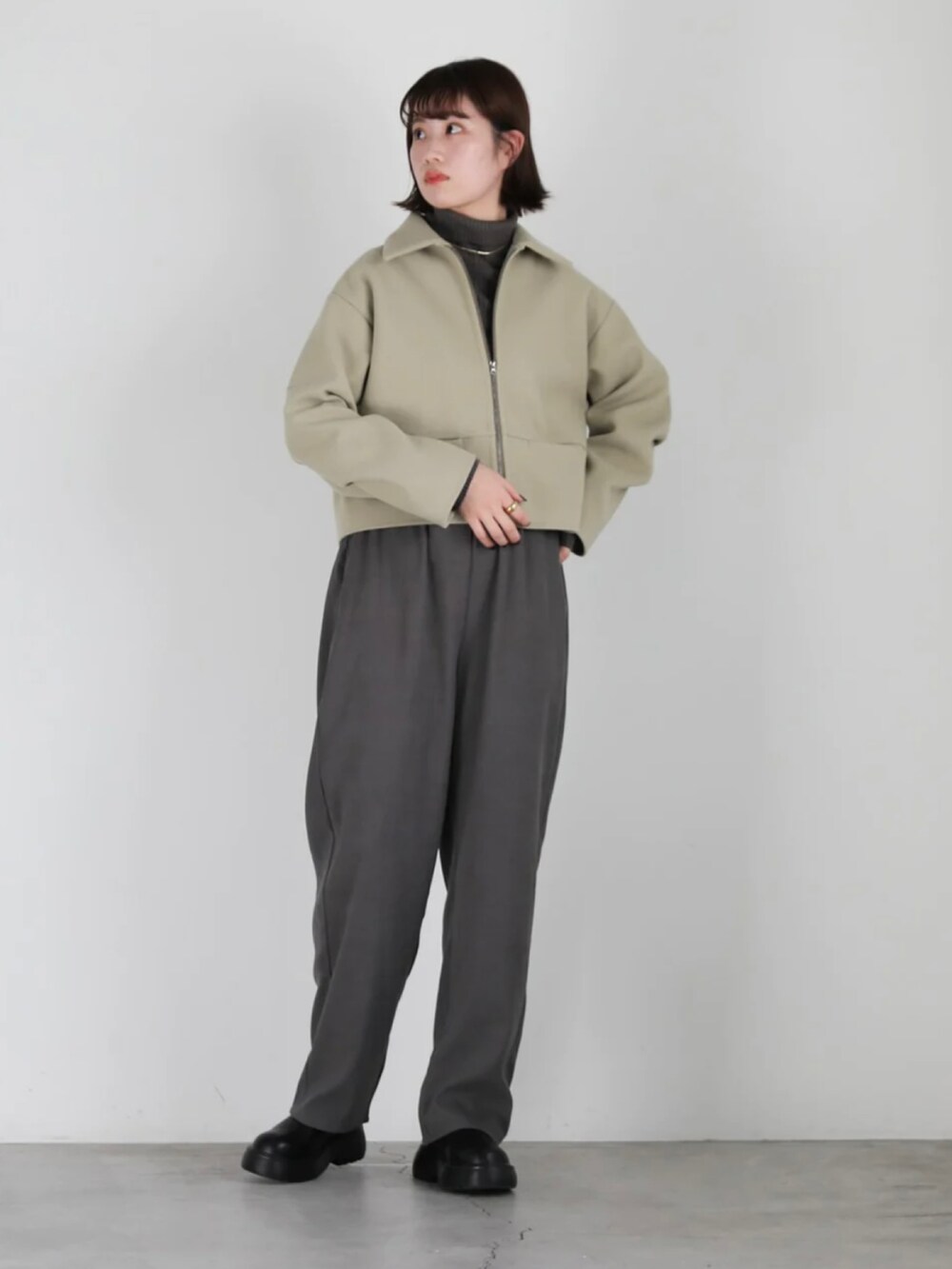 グリーン系のブルゾン、ブラック系のその他パンツ、ブラック系のブーツを着用したレディースの冬コーディネートの3枚目の写真