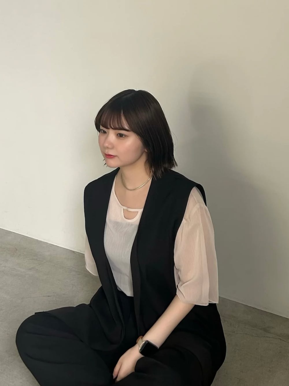 ホワイト系のシャツ/ブラウス、ブラック系のベスト、ブラック系のスラックスを着用したレディースの春コーディネートの4枚目の写真