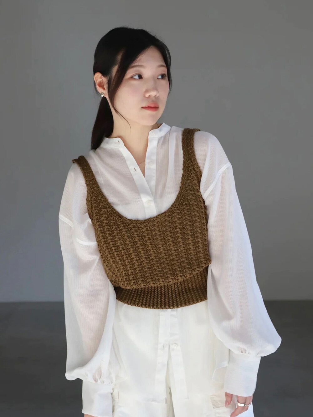 グリーン系のベスト、ホワイト系のシャツ/ブラウス、ホワイト系のカーゴパンツを着用したレディースの春コーディネートの4枚目の写真