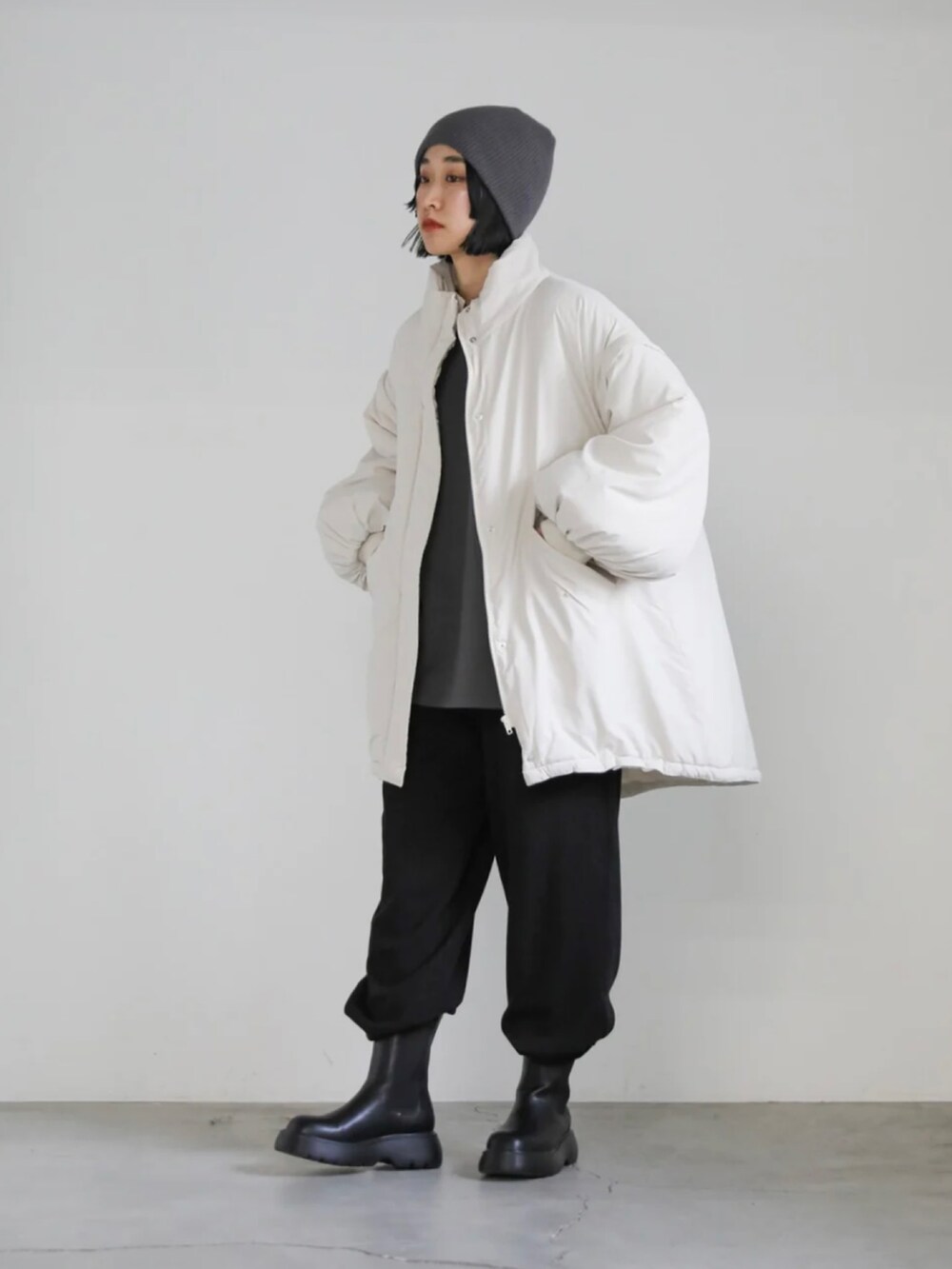 グレー系のスウェット、ホワイト系のダウンジャケット/コート、ブラック系のその他パンツを着用したレディースの冬コーディネートの3枚目の写真