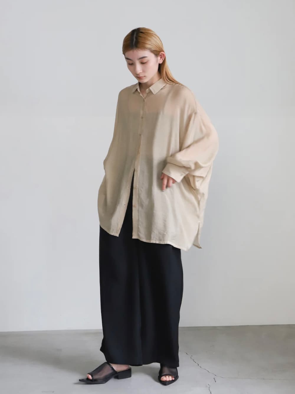 ベージュ系のシャツ/ブラウス、ベージュ系のキャミソール、ブラック系のスラックスを着用したレディースの冬コーディネートの3枚目の写真