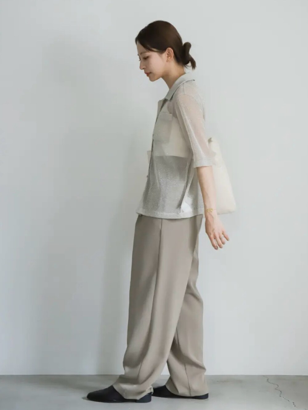 ベージュ系のシャツ/ブラウス、ホワイト系のキャミソール、ベージュ系のスラックスを着用したレディースの夏コーディネートの3枚目の写真