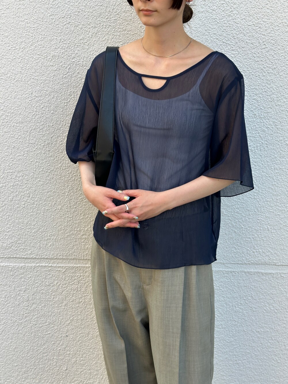 ブルー系のシャツ/ブラウス、グレー系のスラックス、ブラック系のショルダーバッグを着用したレディースの夏コーディネートの5枚目の写真