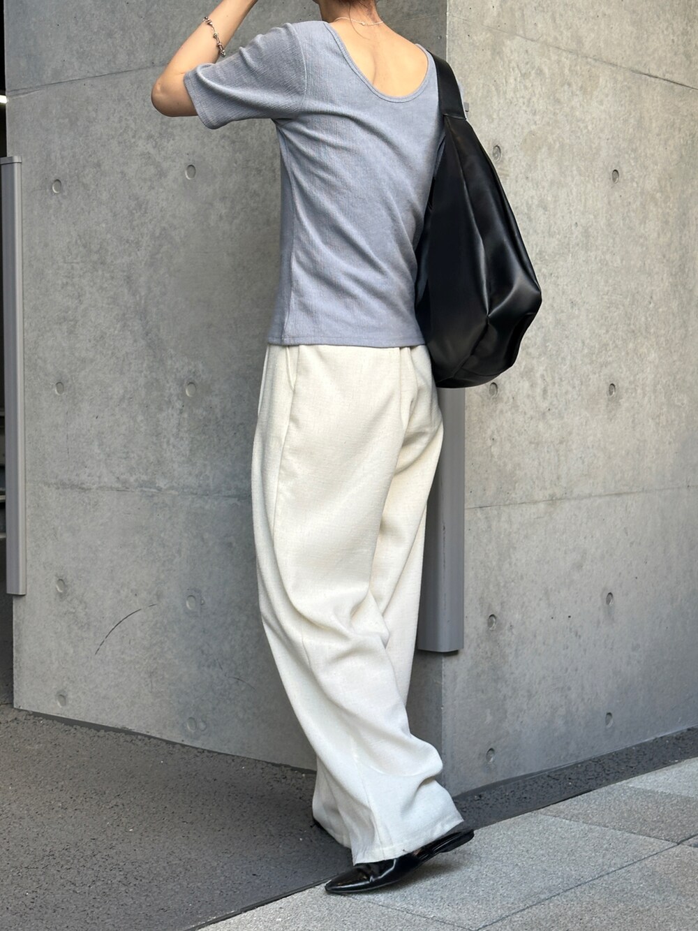 ブルー系のTシャツ/カットソー、ホワイト系のスラックス、ブラック系のトートバッグを着用したレディースの春コーディネートの2枚目の写真