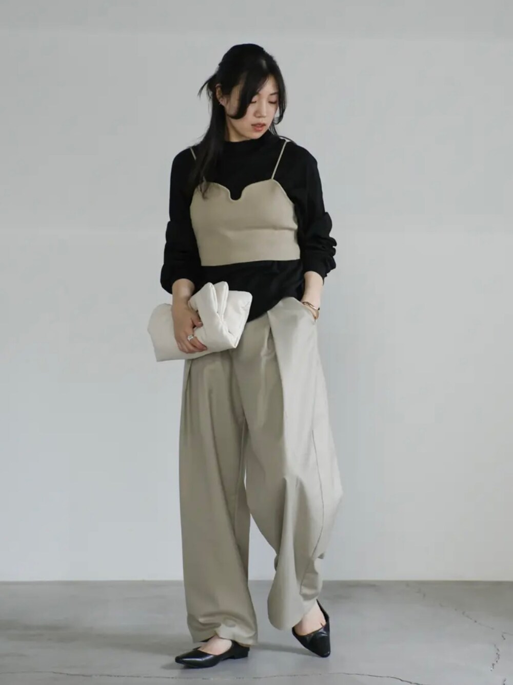 ベージュ系のベスト、ブラック系のTシャツ/カットソー、ベージュ系のスラックスを着用したレディースの夏コーディネートの3枚目の写真