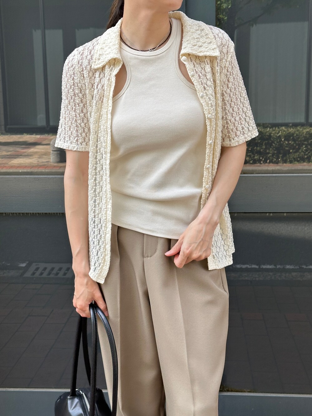 ホワイト系のタンクトップ、ホワイト系のシャツ/ブラウス、ベージュ系のスラックスを着用したレディースの春コーディネートの4枚目の写真