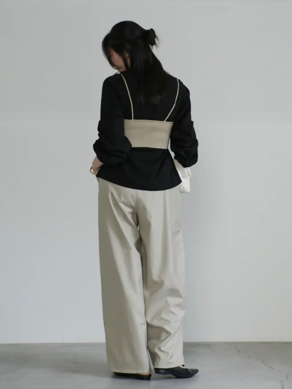 ベージュ系のベスト、ブラック系のTシャツ/カットソー、ベージュ系のスラックスを着用したレディースの夏コーディネートの4枚目の写真