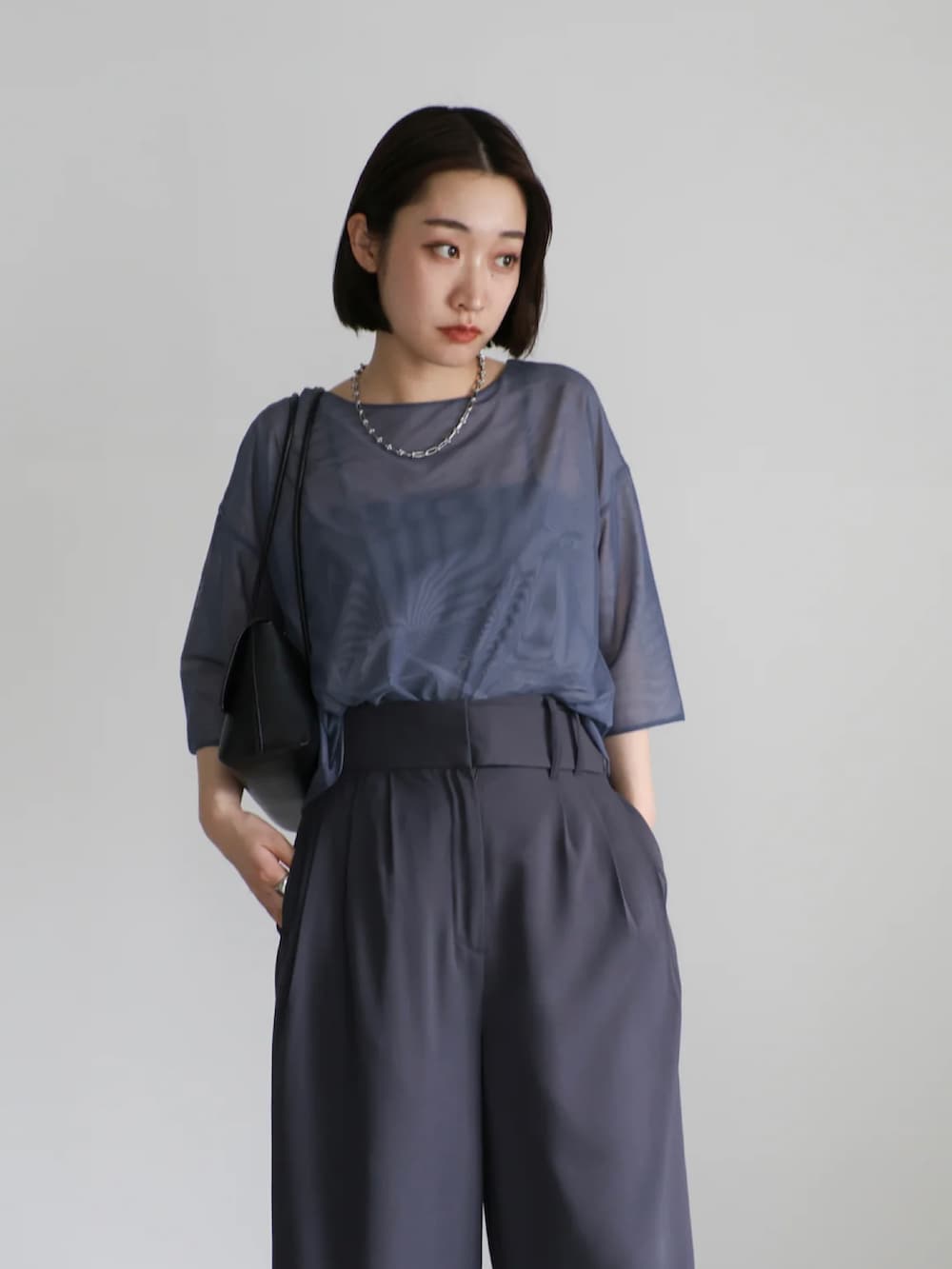 グレー系のTシャツ/カットソー、グレー系のスラックス、ブラック系のキャミソールを着用したレディースの夏コーディネートの4枚目の写真