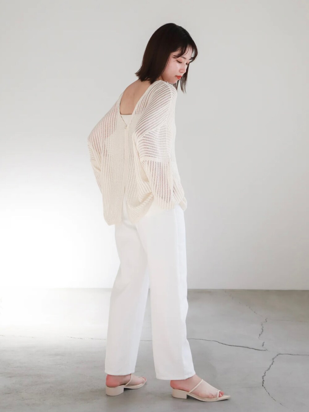 ホワイト系のカーディガン/ボレロ、ホワイト系のキャミソール、ゴールド系のネックレスを着用したレディースの春コーディネートの3枚目の写真