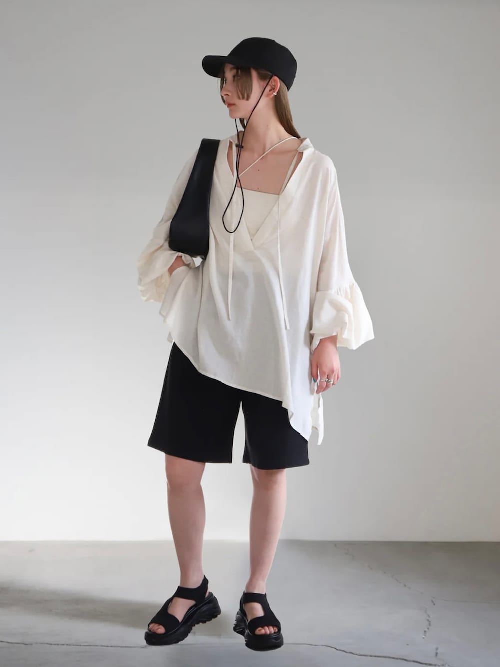 ベージュ系のシャツ/ブラウス、ブラック系のその他パンツ、ホワイト系のキャミソールを着用したレディースの春コーディネートの2枚目の写真