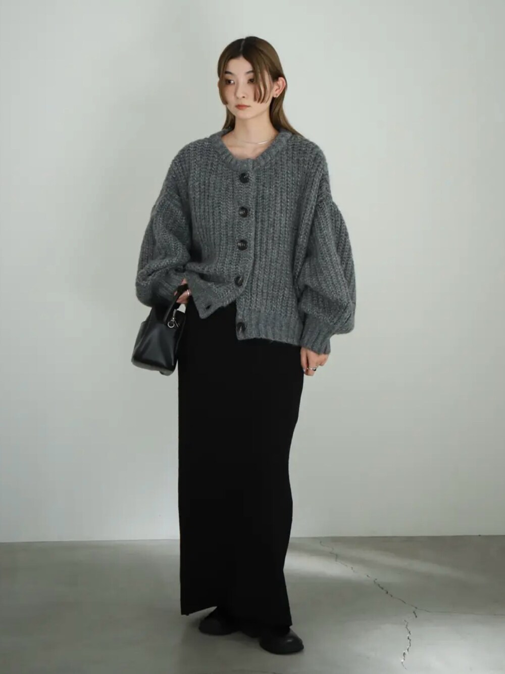 グレー系のカーディガン/ボレロ、ブラック系のスカート、ブラック系のスリッポンを着用したレディースの夏コーディネートの4枚目の写真