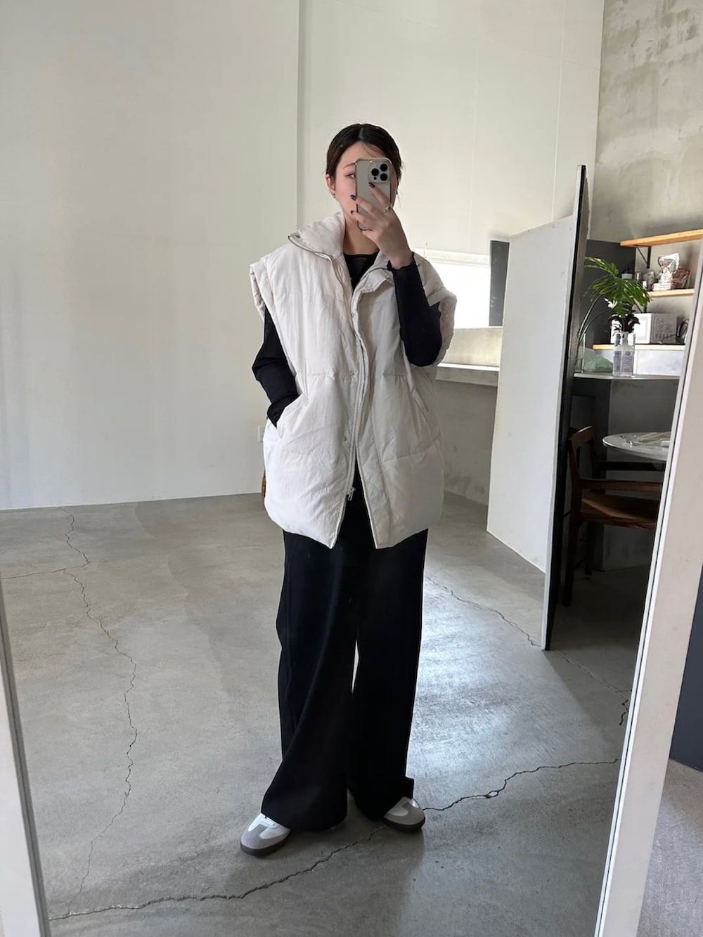 ホワイト系のダウンベストを着用したレディースの冬コーディネートの2枚目の写真