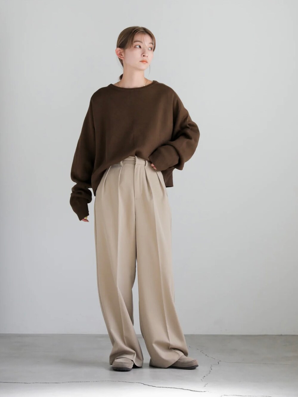 ブラック系のニット/セーター、ベージュ系のスラックスを着用したレディースの秋コーディネートの3枚目の写真