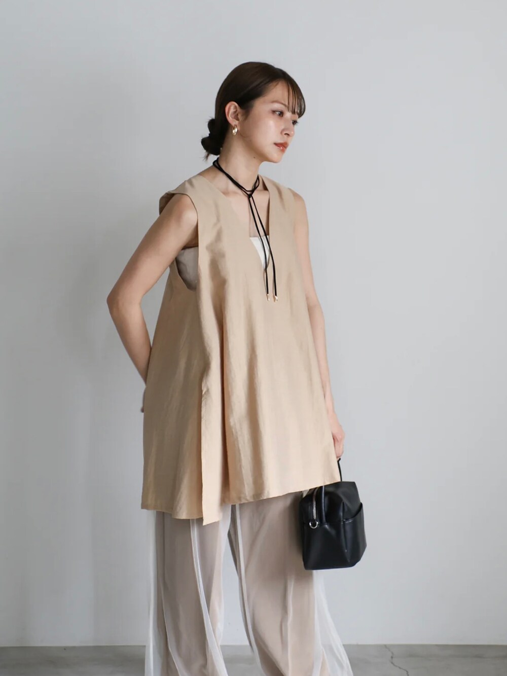 ベージュ系のベスト、ホワイト系のキャミソール、ホワイト系のその他パンツを着用したレディースの夏コーディネートの5枚目の写真