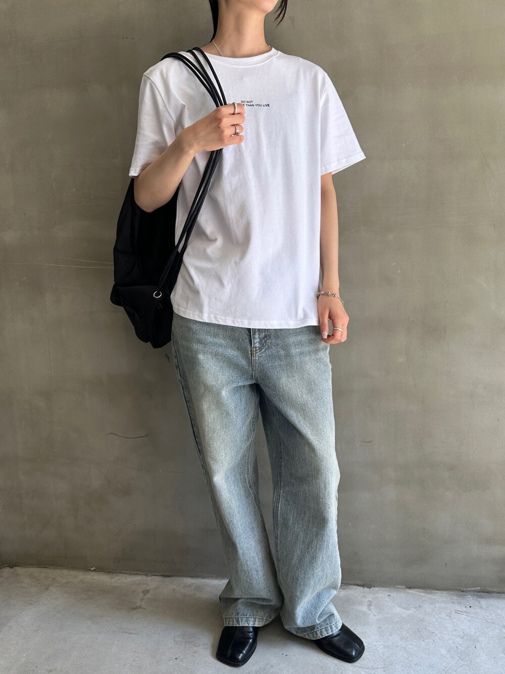 ホワイト系のTシャツ/カットソー、ブルー系のデニムパンツ、ブラック系のバックパック/リュックを着用したレディースの春コーディネートの3枚目の写真