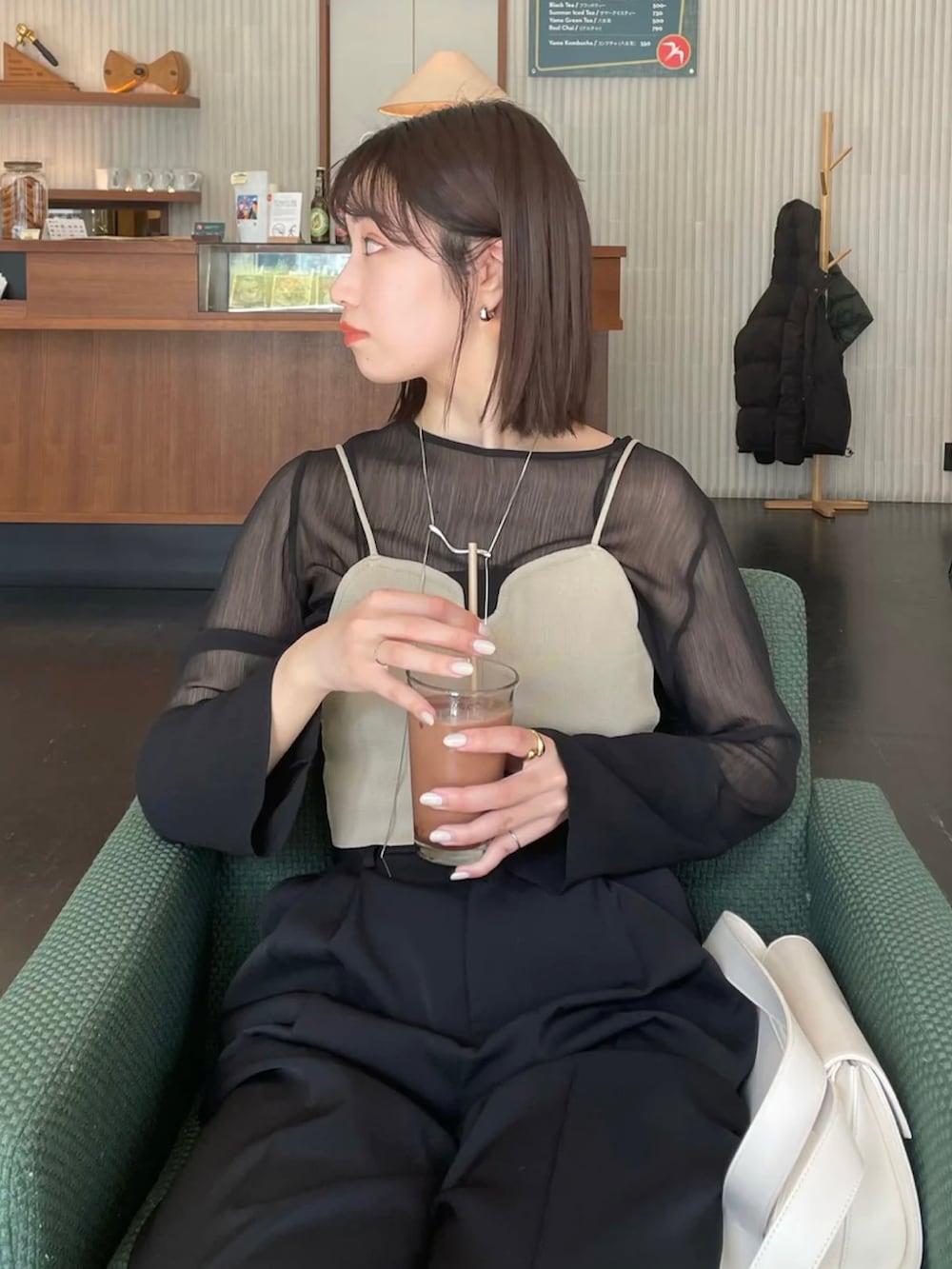 ブラック系のシャツ/ブラウス、ベージュ系のベスト、ホワイト系のショルダーバッグを着用したレディースの春コーディネートの5枚目の写真