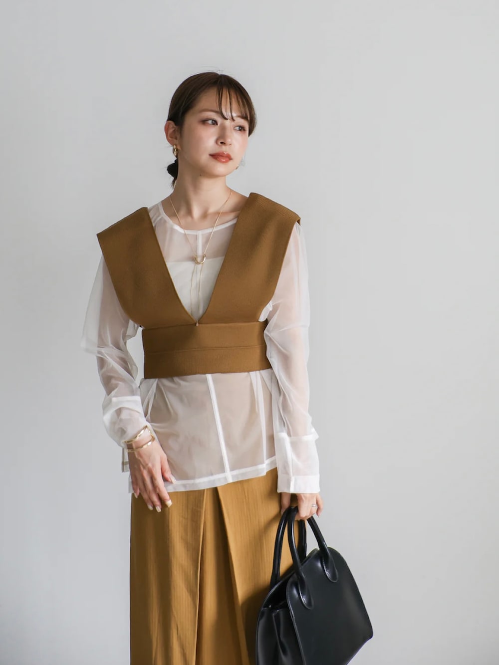 ホワイト系のキャミソール、ホワイト系のTシャツ/カットソー、グリーン系のベストを着用したレディースの夏コーディネートの4枚目の写真
