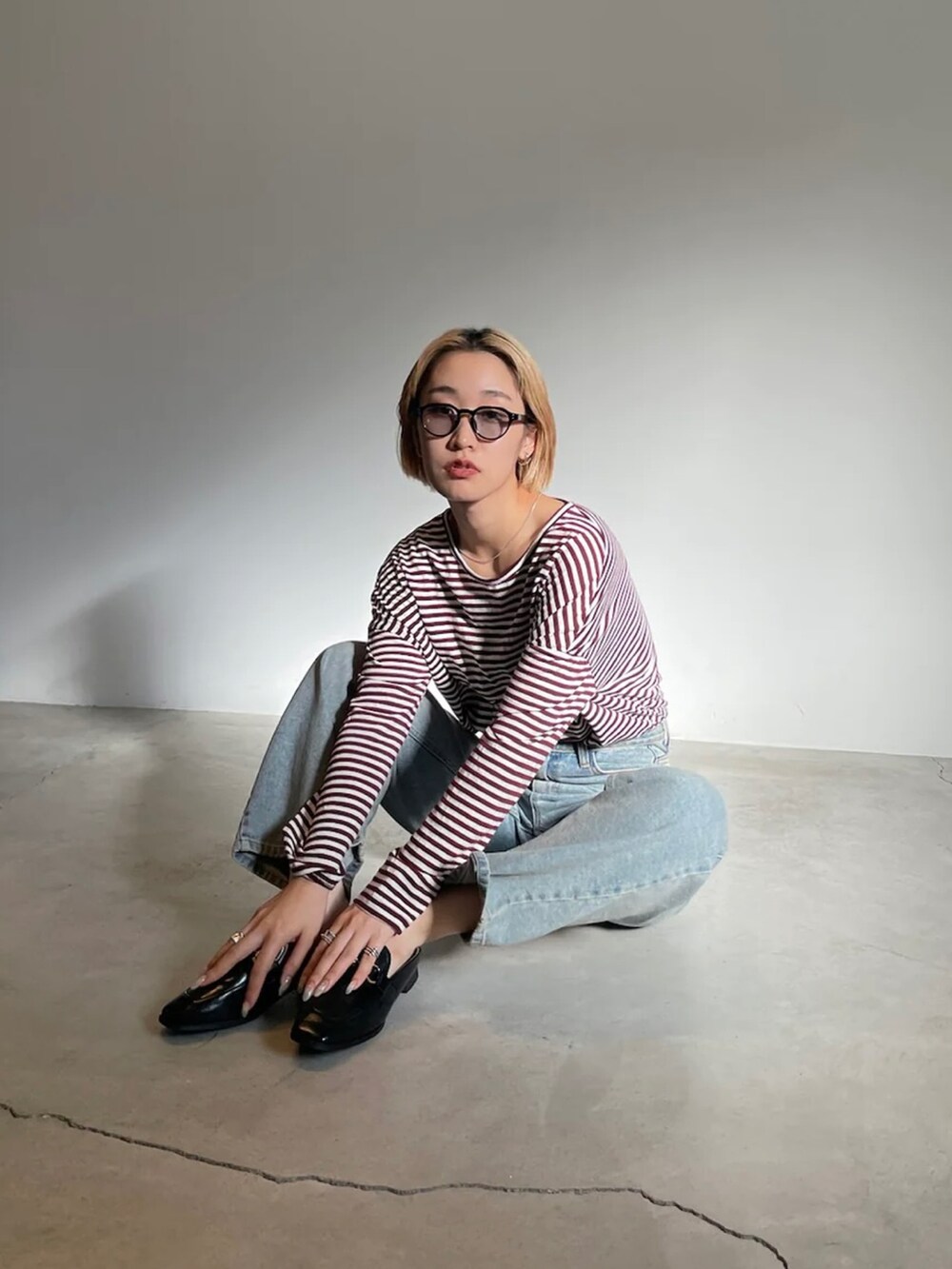 レッド系のTシャツ/カットソー、ブラック系のローファー、ブラック系のサングラスを着用したレディースの夏コーディネートの2枚目の写真