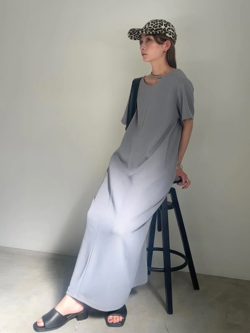 グレー系のワンピース、ブラック系のサンダルを着用したレディースの春コーディネートの2枚目の写真